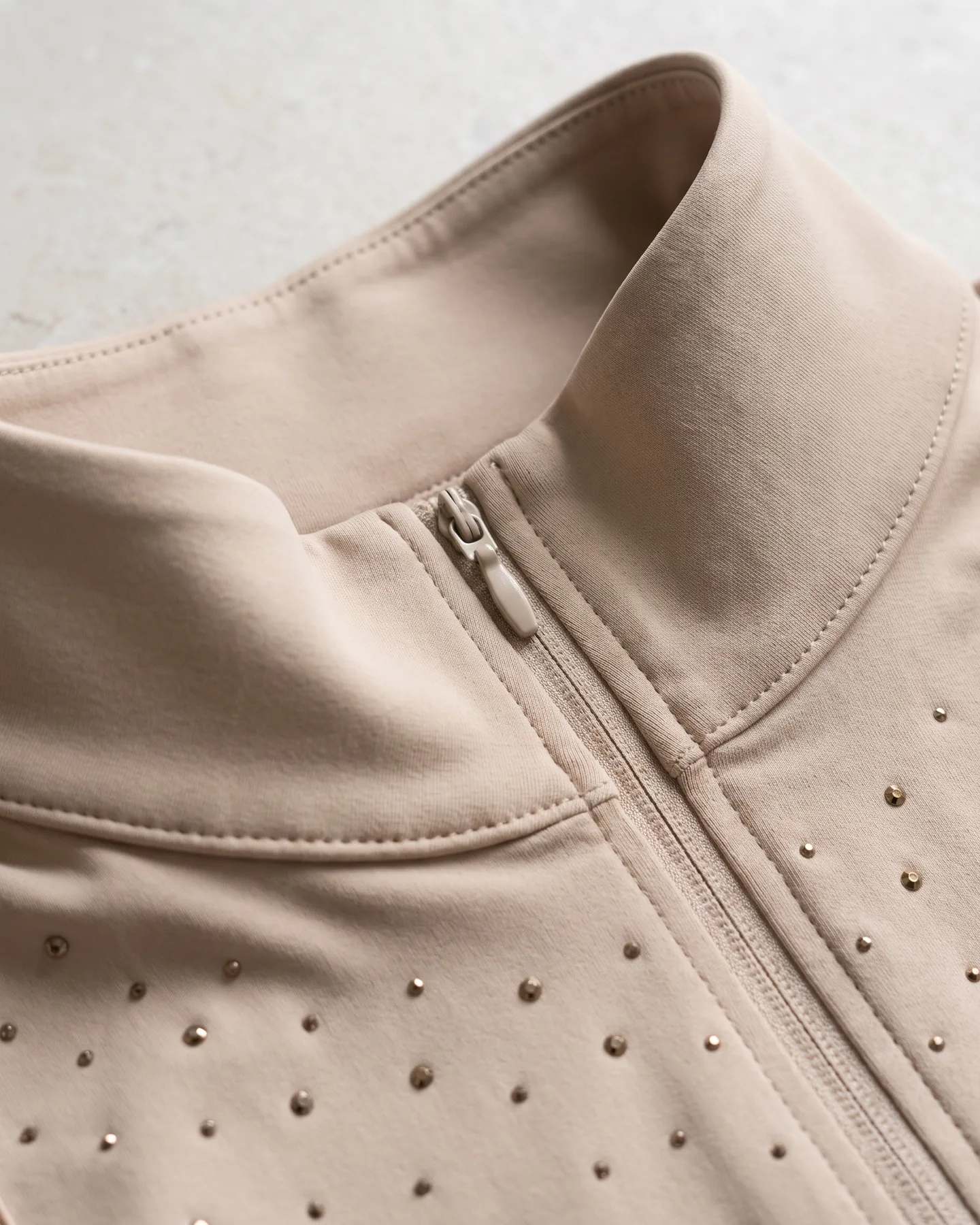 Col montant et patte zippée d’une chemise de concours beige semée de strass (illustration générée par IA d’après notre échantillon)